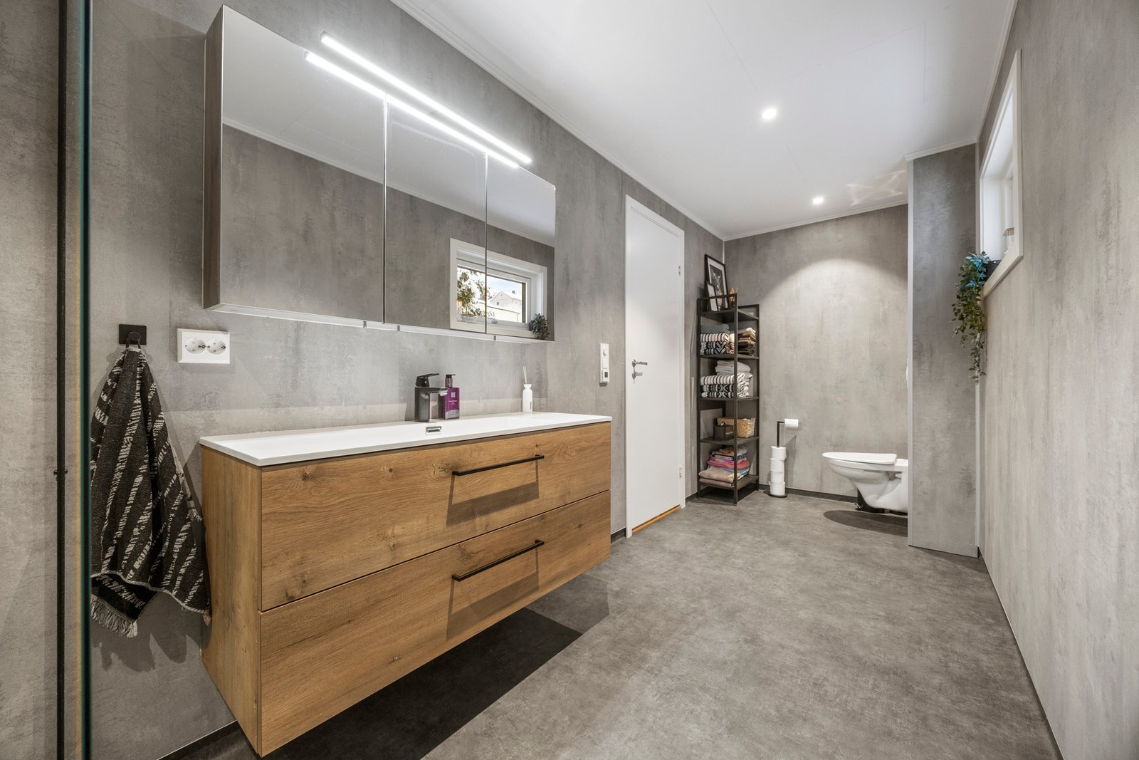 Utstyrt med servantskap, dusjhjørne og vegghengt toalett Galleribilde