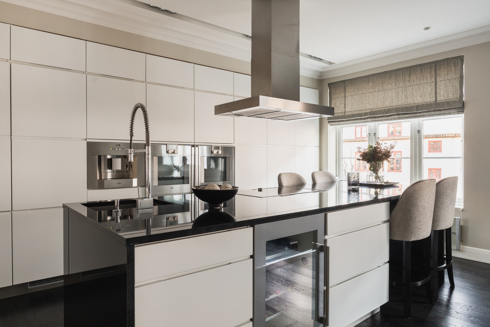 Stilrent, minimalistisk kjøkken med glatte fronter og benkeplate i stein. Galleribilde