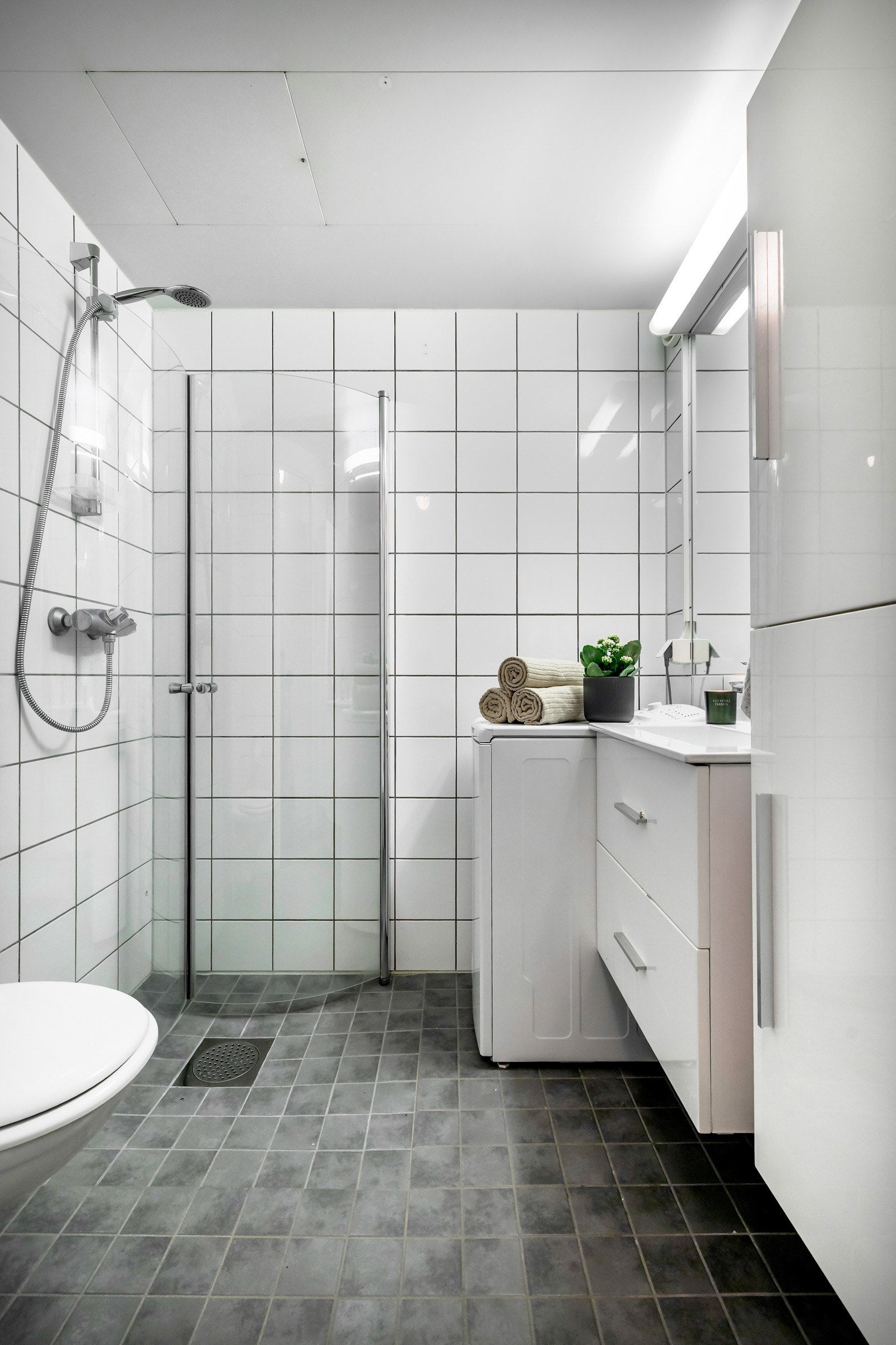 Over servanten finner du et stort speil med belysning. Det er varmekabler i gulvet og opplegg for vaskemaskin. Galleribilde