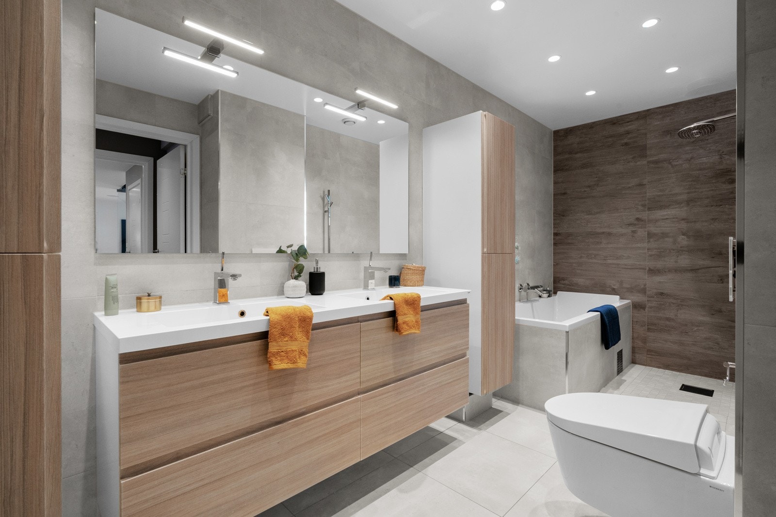 Badet holder en moderne standard med flislagte overflater og vannbåren gulvvarme. Innmurt badekar og dusj. Dobbel servant