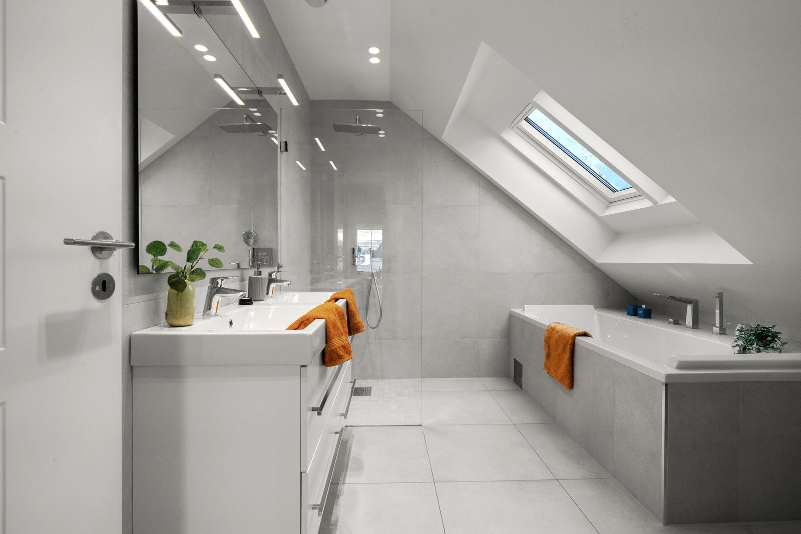 Et stilfullt flislagt bad med vannbåren gulvvarme som gir en behagelig varme året rundt