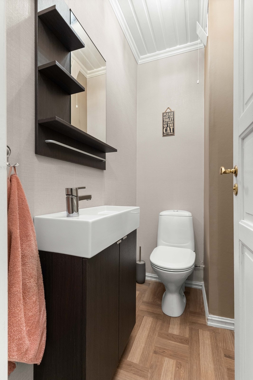 Inngangsplanen har et delikat og moderne toalettrom som er utstyrt med servant, speil med oppbevaringshyller og et toalett. Galleribilde