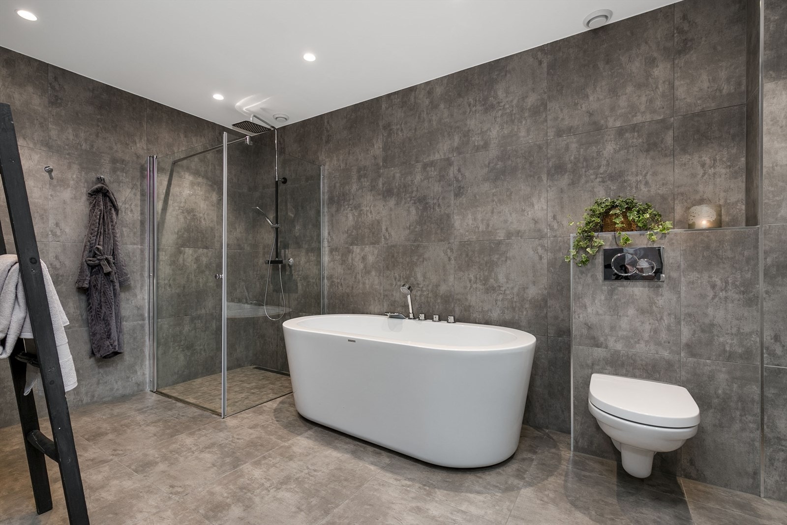 På badet er det både et dusjhjørne og et flott badekar med dusjløsning, der førstnevnte har slukrenne, regnfallsdusj og innfellbare glassdører. Galleribilde