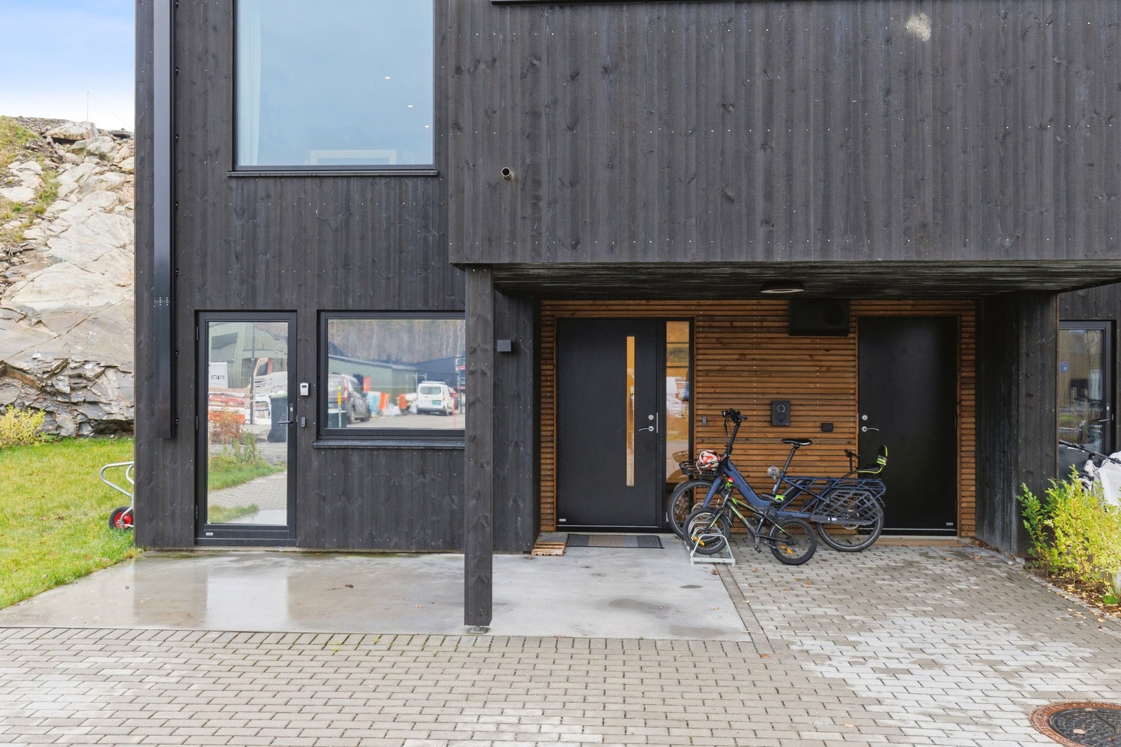 Uteområde med inngangsparti. Inngangsdør for hybel til venstre med speilet solfilm for mindre innsyn og blokkering av solvarme. Egen inngangsdør til bod, med videre passasje til vaskerom/bad. Galleribilde