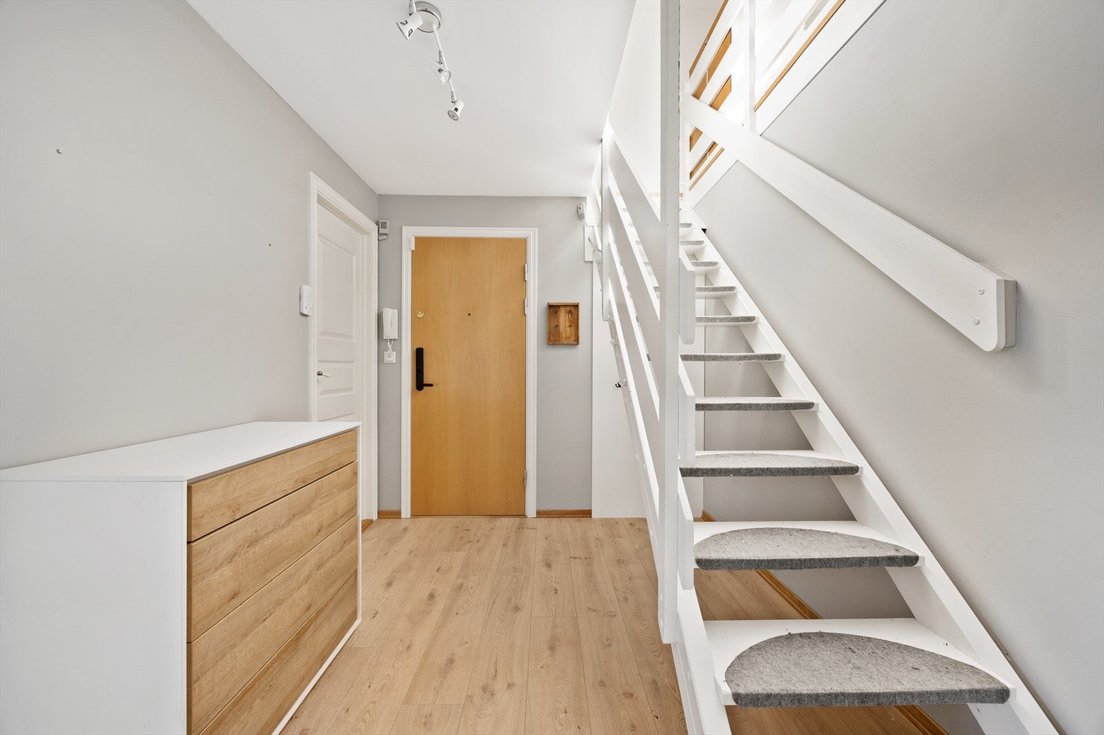 Lys entré med plass til oppbevaring og trapp som forbinder leilighetens to plan. Galleribilde