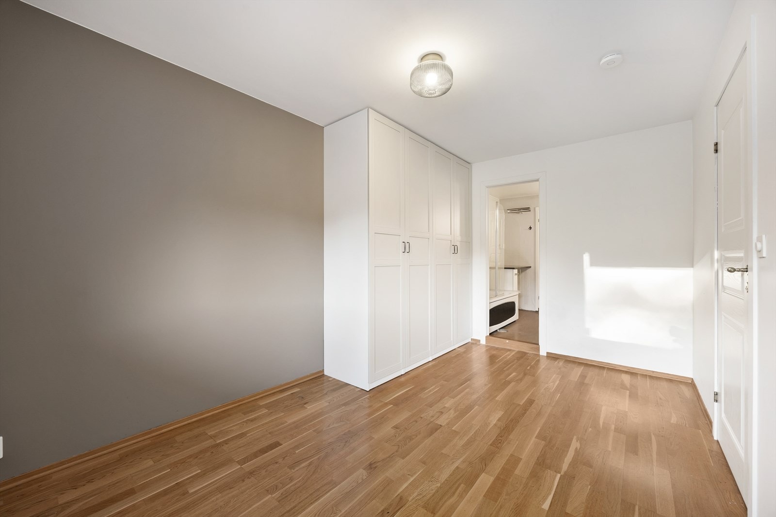 Rommet har parkett på gulvet og en nøytral fargepalett. Galleribilde