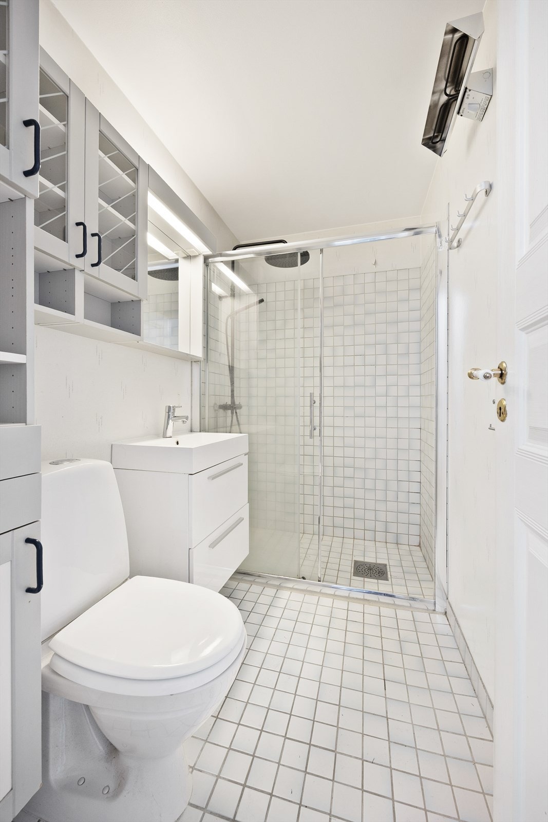 Bad i 4. etasje med flislagt gulv og dusjhjørne med dører i herdet glass. Galleribilde