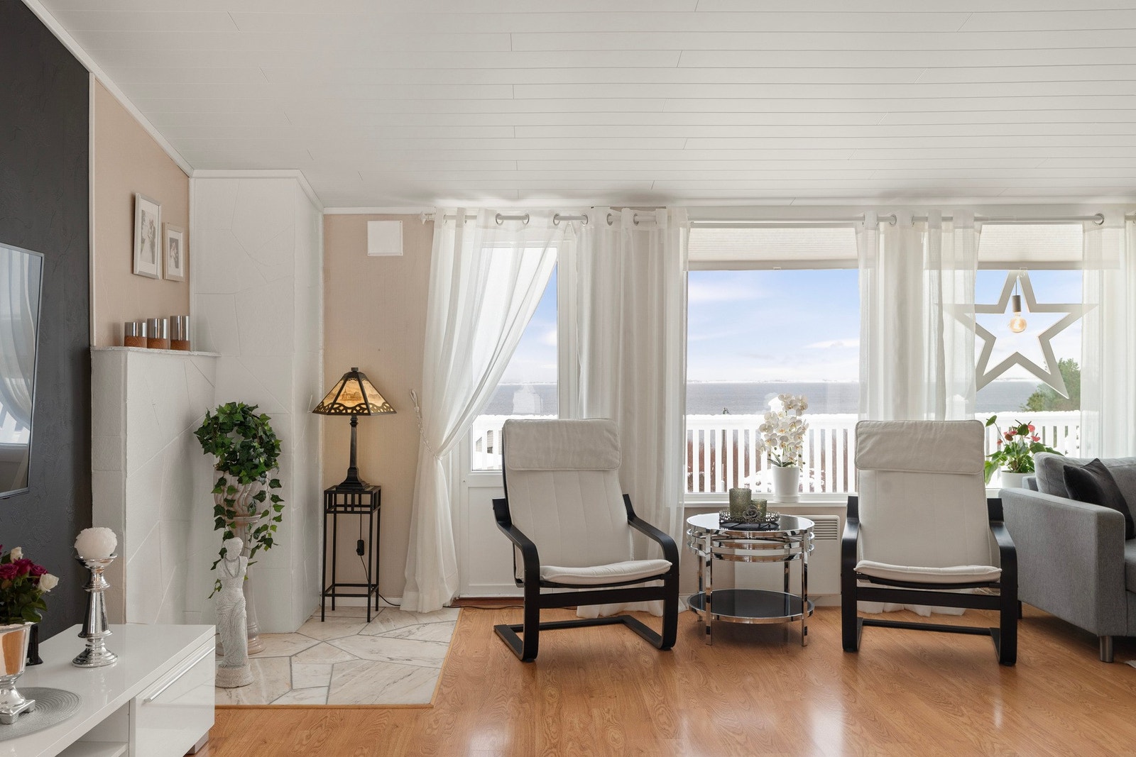 Dagslyset strømmer inn til stuen via store, nordvendte vinduer. Galleribilde