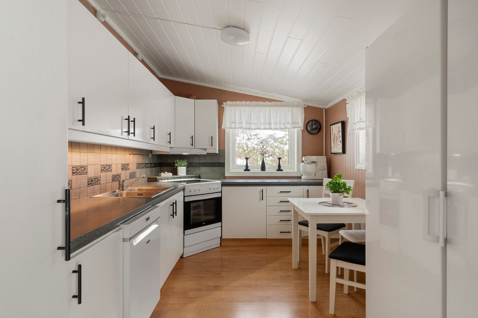 Kjøkkenet har et stilrent og pent design med god skap- og benkeplass. Galleribilde