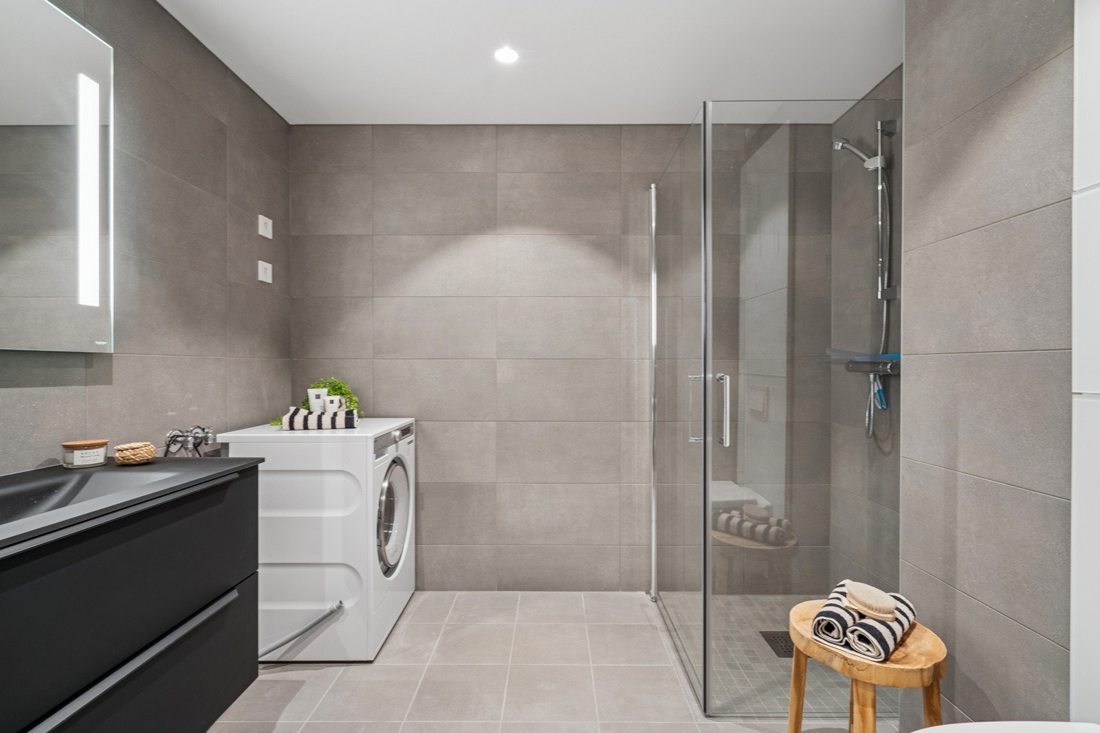 Delikat bad med moderne flislagte overflater, gulvvarme og downlightsbelysning. Galleribilde