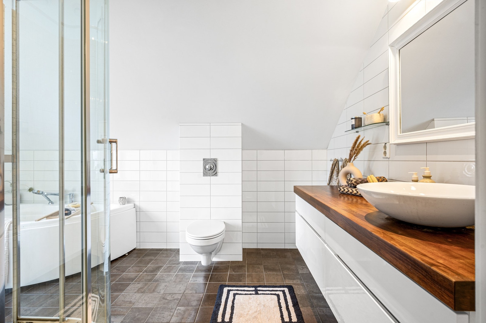 Hovedbaderommet er lekkert og meget romslig. Dette badet har moderne farger og materialvalg og fremstår som meget pent. Badet har dusjkabinett og badekar. Galleribilde