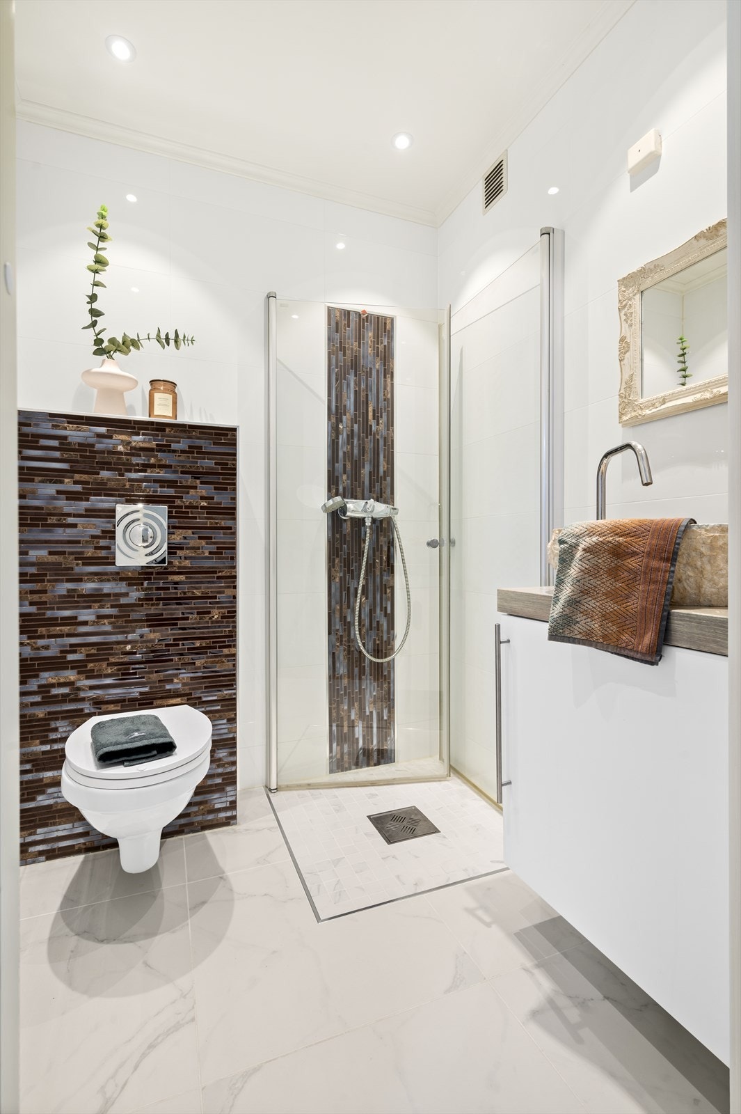 Ved entréen i 1.etg. er det et lekkert bad med toalett, dusj og servantskap. Varmekabler i gulv. Galleribilde