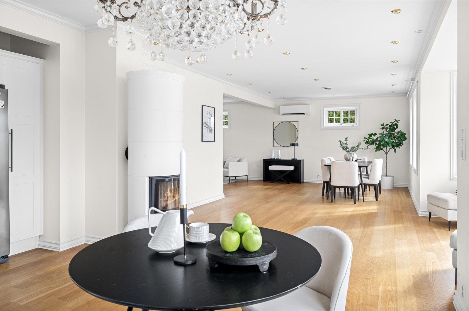 En stor sirkelrund peisovn med elegant og stilrent preg er plassert midt mellom de sosiale rommene, slik at flammene kan sette sitt preg på stuen, kjøkkenet og spisestuen. Galleribilde