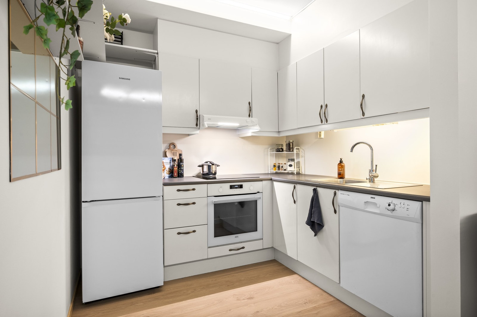 Det er rikelig med oppbevaringsplass i skuffer og skap. Den gode benkeplassen gjør matlagingen enkel. Platetopp, stekeovn og oppvaskmaskin er integrert i innredningen. Galleribilde