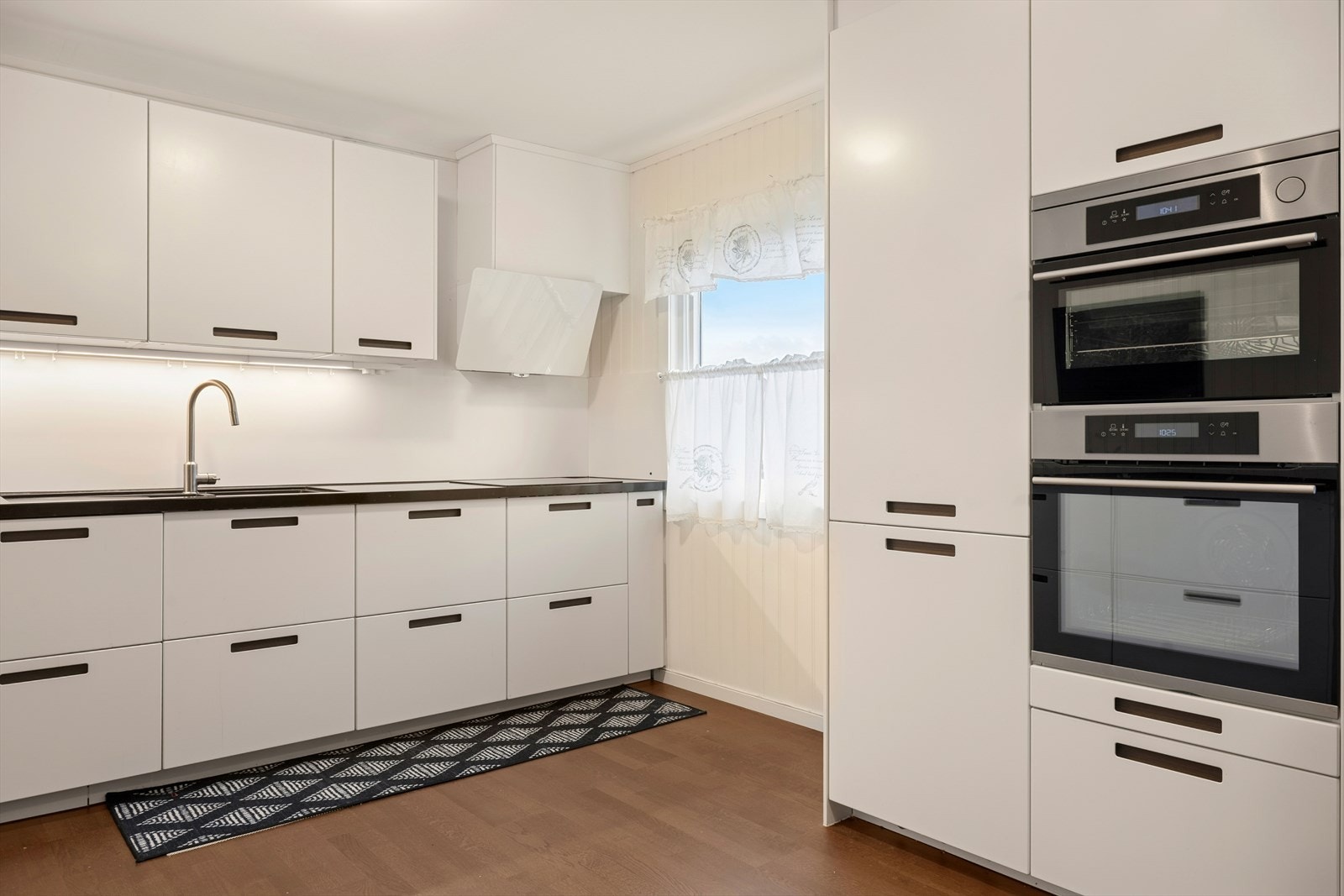 Kjøkkenet er innredet slik at matlagingen forenes med sosialt samvær. Galleribilde