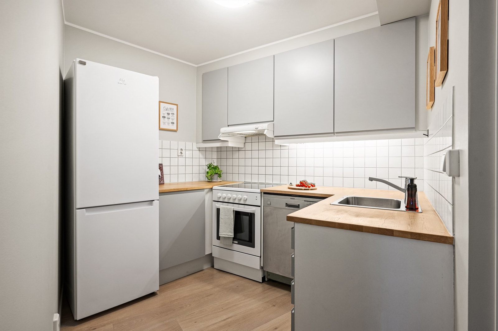 Innredningen har glatte fronter og opplegg for komfyr, oppvaskmaskin og kjøleskap. Solid benkeplate i heltre ble byttet i 2022. Galleribilde