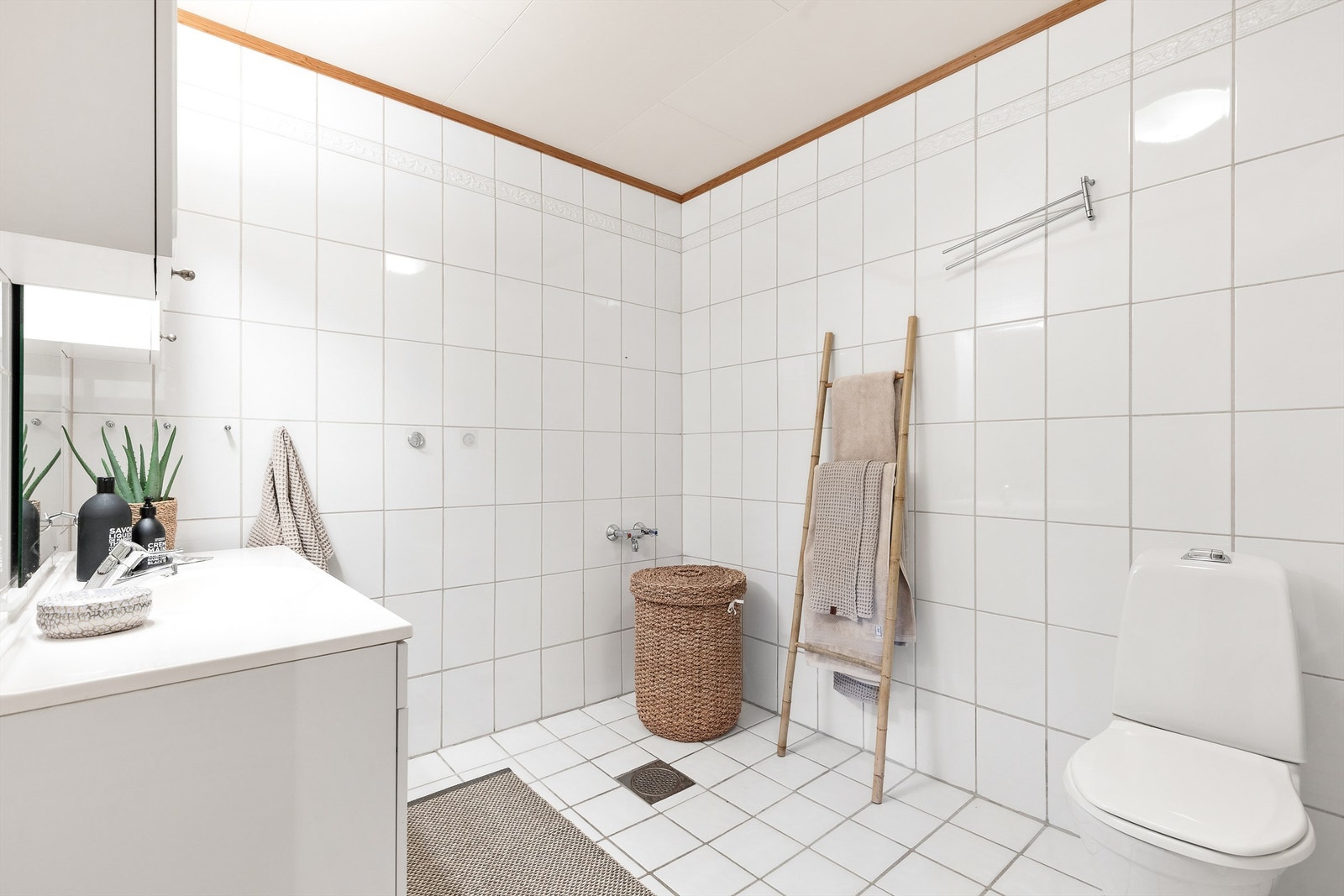 Stort bad fra byggeår. Flislagt gulv med gulvvarme, flislagte vegger og himling av himlingsplater. Galleribilde