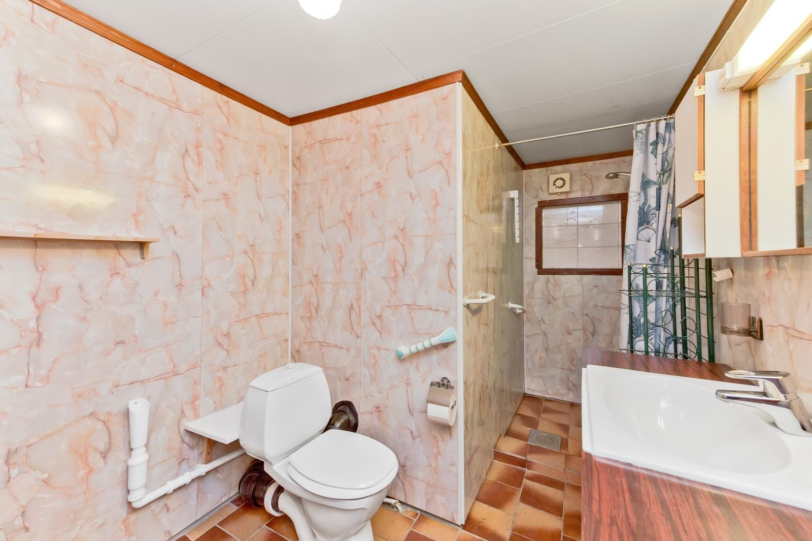 Bad med opplegg for vaskemaskin og tørketrommel. Dusjsonen er oppgradert med nyere veggplater Galleribilde