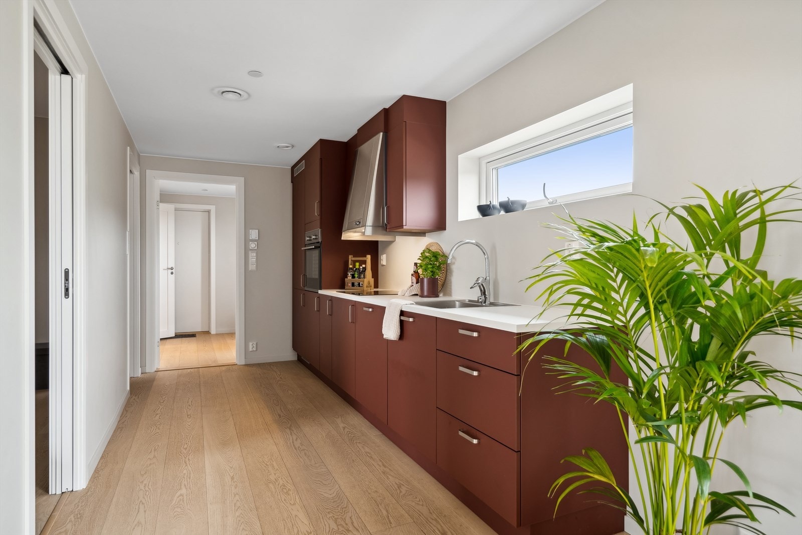 Kjøkkeninnredningen er godt utbygget og har moderne fronter i vinrød farge samt en pen laminatbenkeplate. Galleribilde