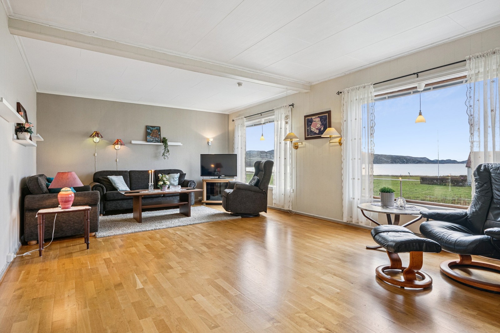 Stuen er rik på dagslys og praktfull utsikt mot forden gjennom de store vindusflatene. Galleribilde