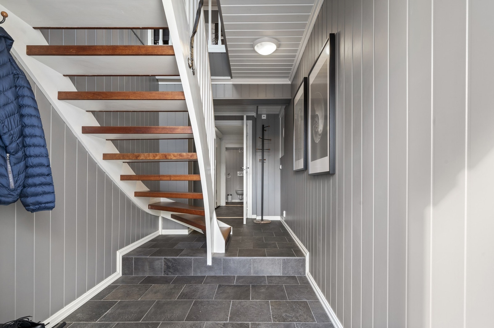 Videre tar trappen deg ned til 1. etasje. Det gjøres oppmerksom på at rommene i 1. etasje er opprinnelig byggemeldt som fyrrom og garasje og er derfor ikke godkjent for varig opphold. Se pkt. ferdigattest Galleribilde