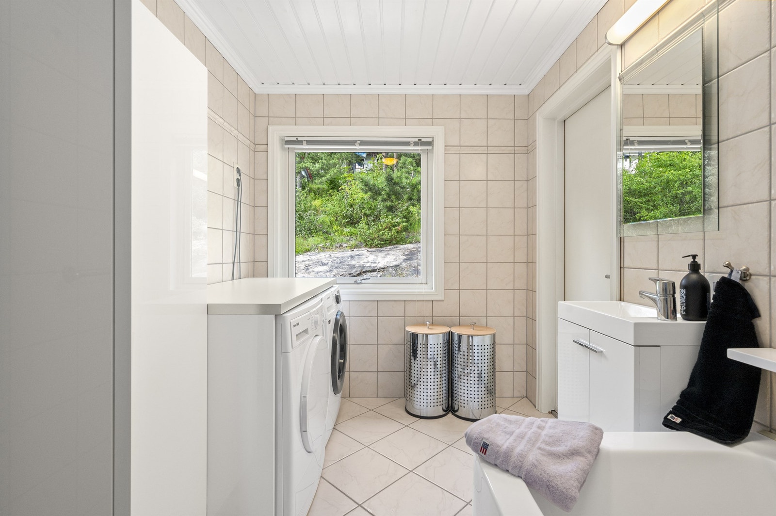 Det første badet fungerer også som et vaskerom og er innredet med badekar med dusj og servantskap med servant. Galleribilde