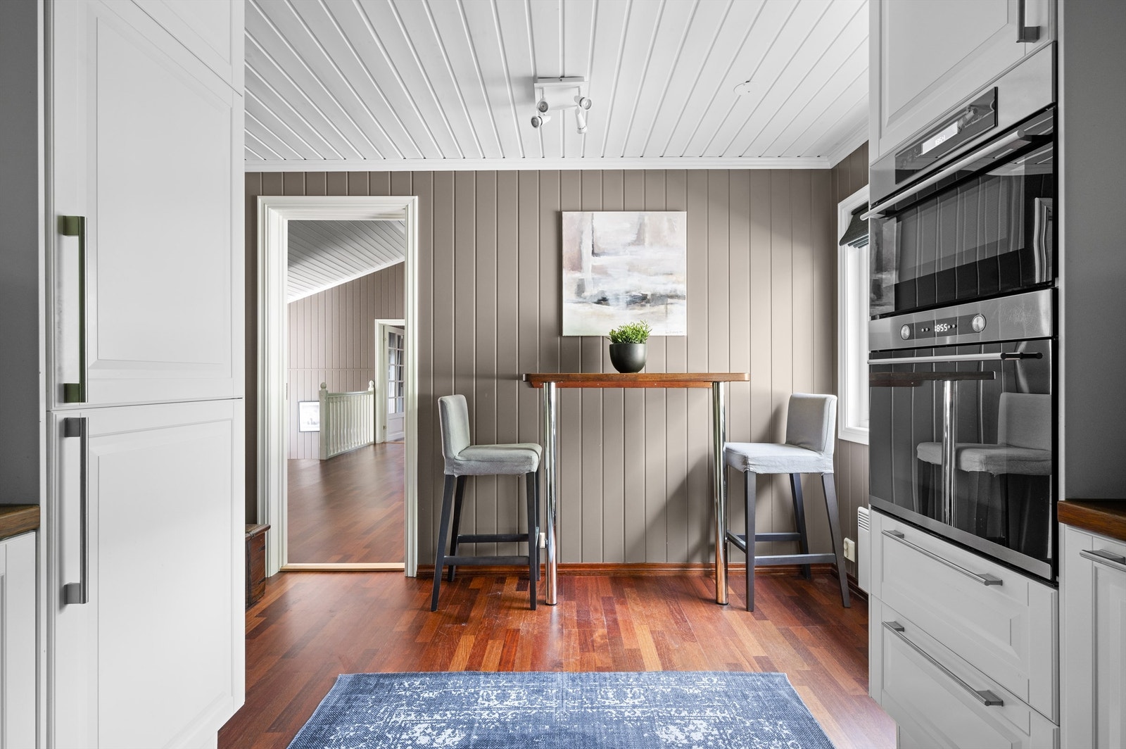 Kjøkkeninnredningen er fra IKEA og består av tidløse fronter. Benkeplate i heltre med vaskekum. Hvitevarene er sømløst integrert i innredningen og består av kjøleskap med fryser, mikrobølgeovn, komfyr og platetopp. Galleribilde