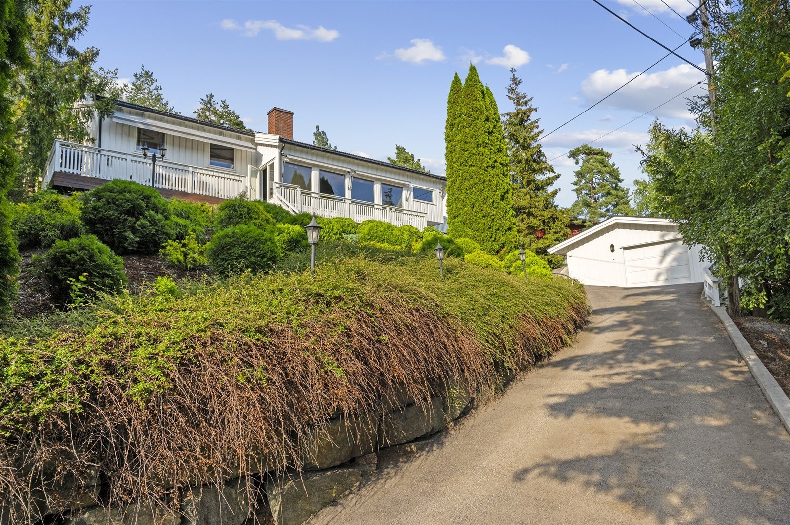 I innkjørselen finner du boligens dobbelgarasje. Garasjen har plass til to mindre biler. Det er montert eget sikringsskap innen for porten til venstre med automat sikringer. Galleribilde