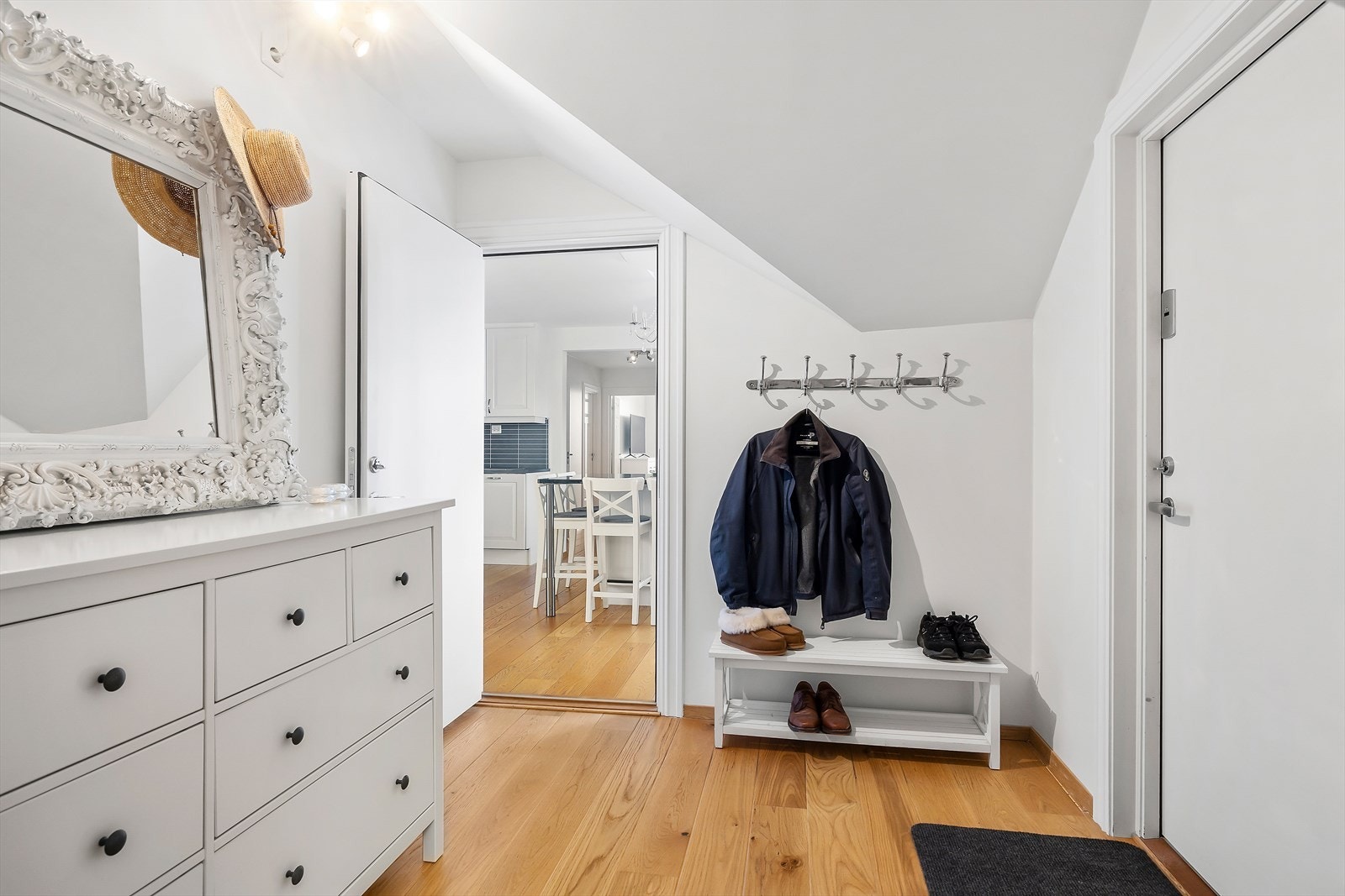 Velkommen inn! Fra inngangshallen går du rett inn på kjøkkenet til høyre, til venstre finner du hybel/soverom med tilhørende bad og kjøkken. Galleribilde