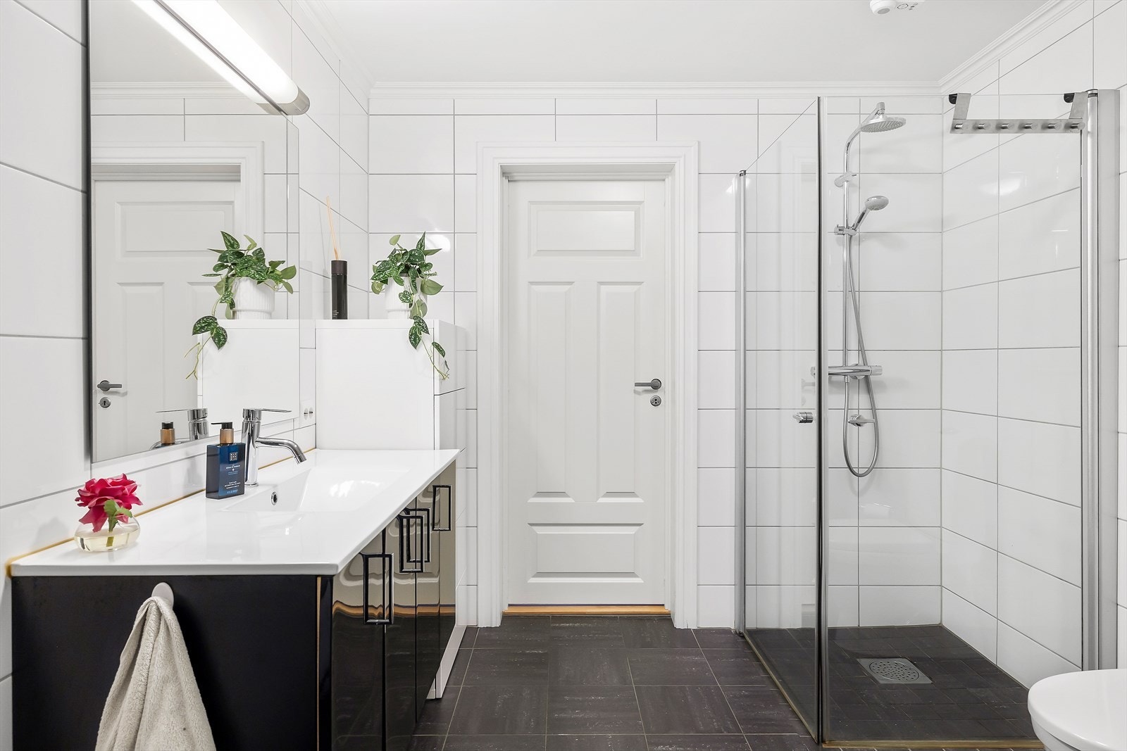 Innredning med nedfelt servant, gulvmontert toalett og dusjhjørne med glassvegger. Galleribilde