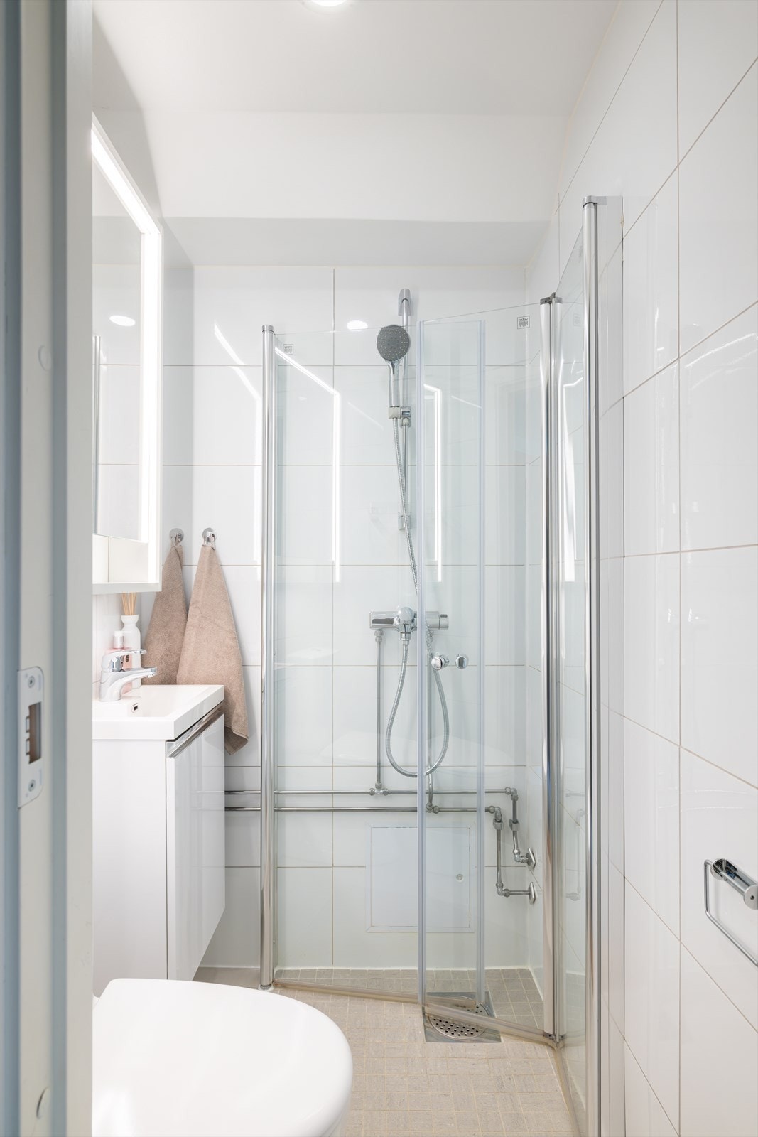 Tidløst bad fra 2017 med lyse fliser på vegger og gulv, samt elektriske varmekabler. Galleribilde