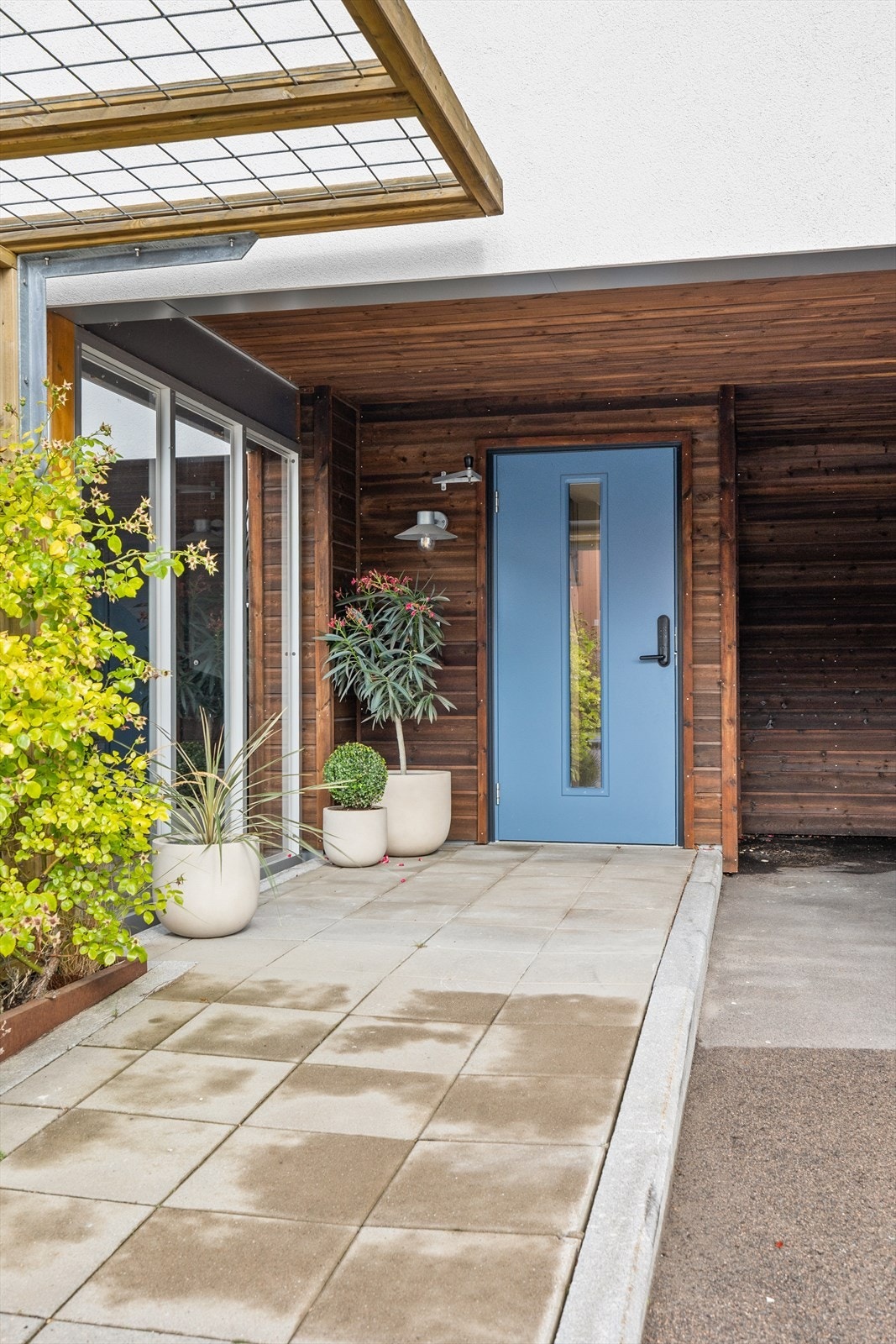Utenfor inngangen har man carport med elbillader og ekstra plass til 1-2 biler. Galleribilde