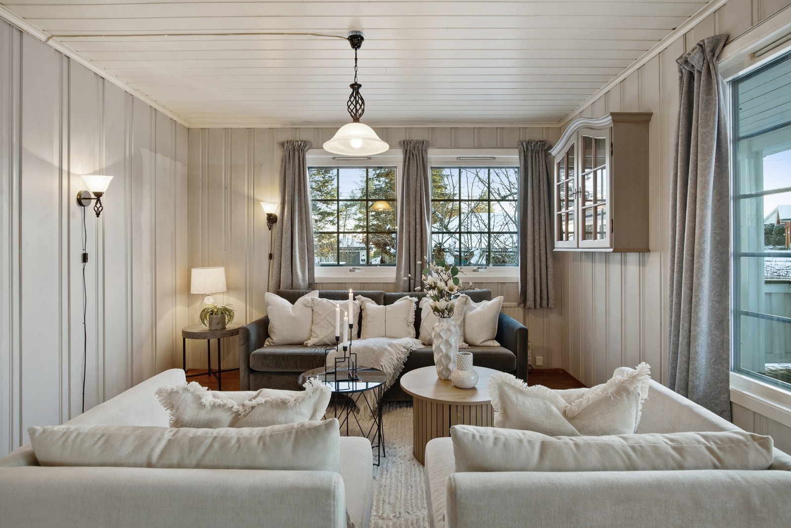 Vegger med malt trepanel og store vindusflater gir rommet karakter. Galleribilde