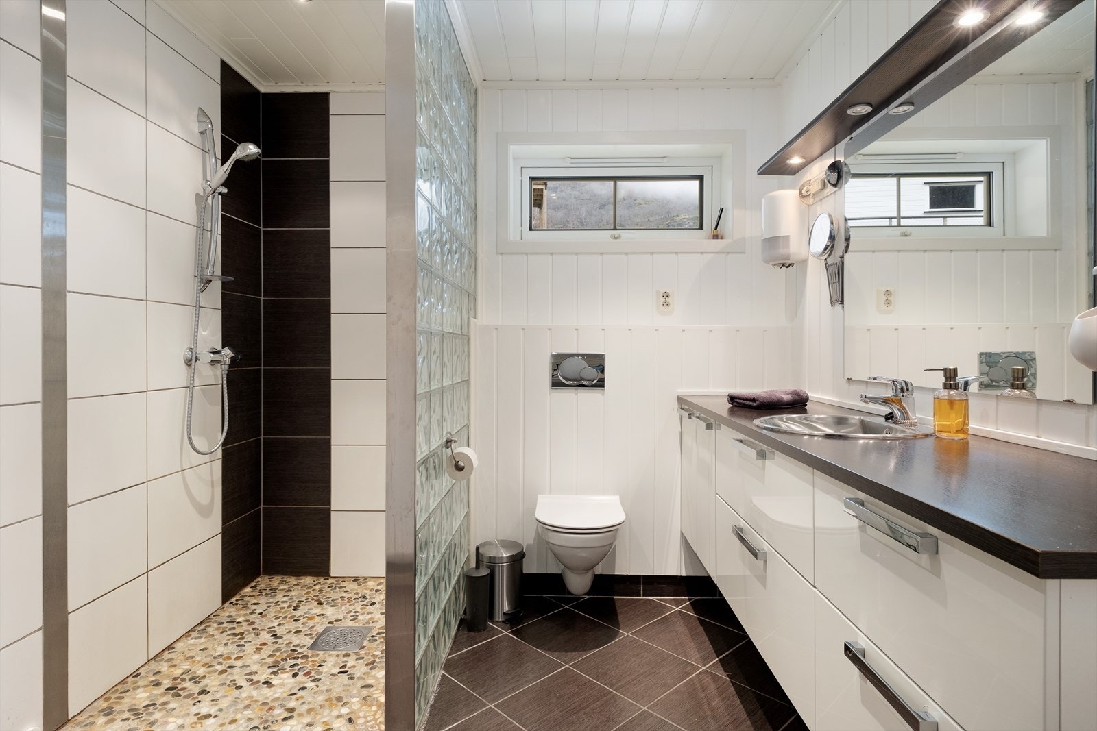 Hovedbad med flis på golv, delvis flis på veggar, og enkelte veggar med panel. Galleribilde