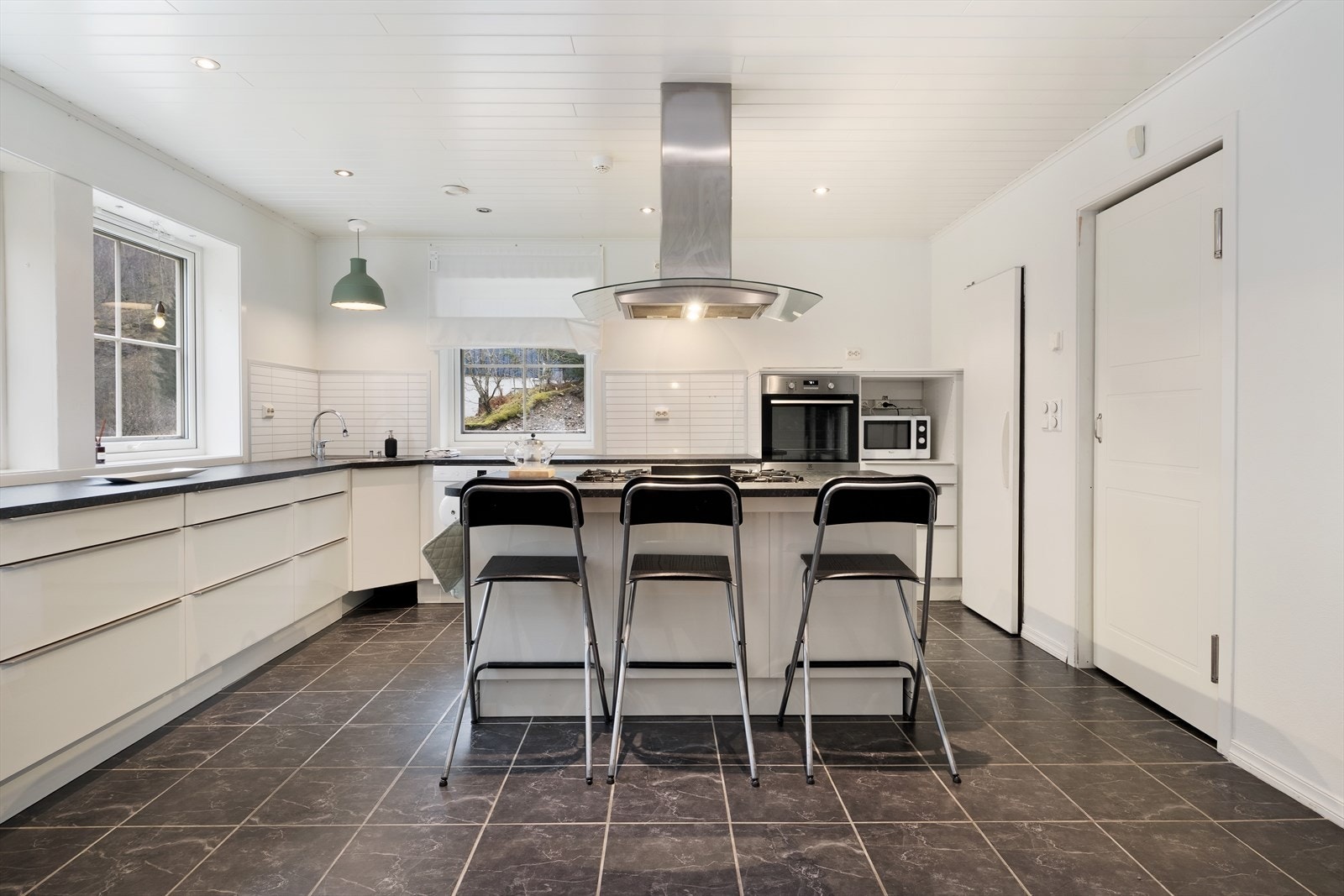 Kjøkkenet har ei tidlaus innreiing med kvite glatte møbelfrontar og svart benkeflate. Galleribilde