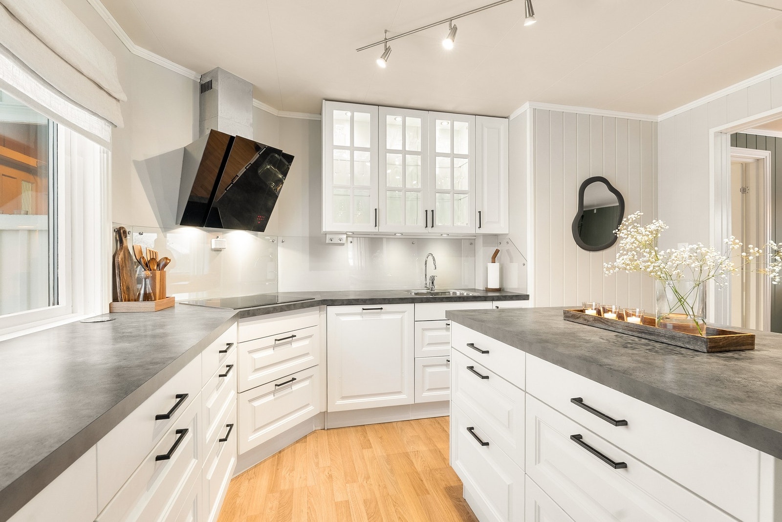 Kjøkken med hvite profilerte fronter, integrert komfyr og oppvaskmaskin. Svært god skap- og benkeplass! Galleribilde