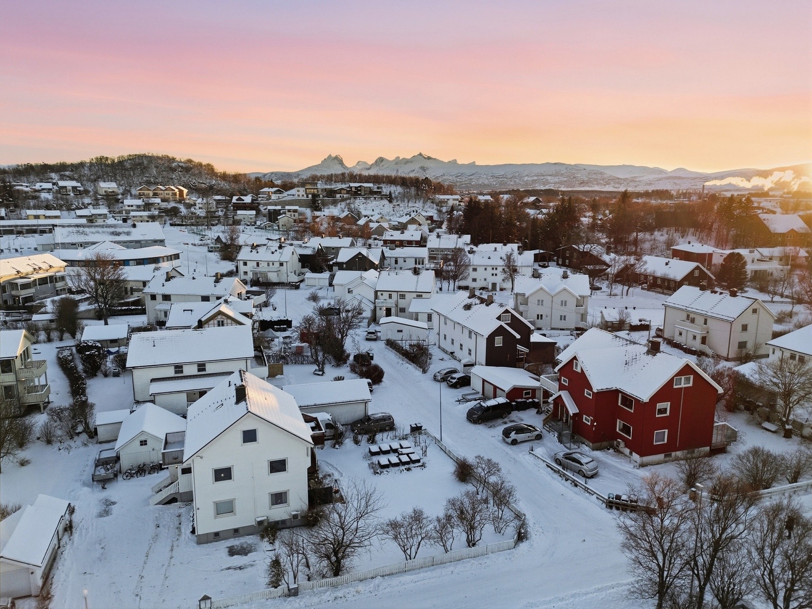 Oversiktsbilde av tomannsboligen med ny oppgradert taktekking fra 2024 og gruset parkeringsplass med utvidet areal. Galleribilde