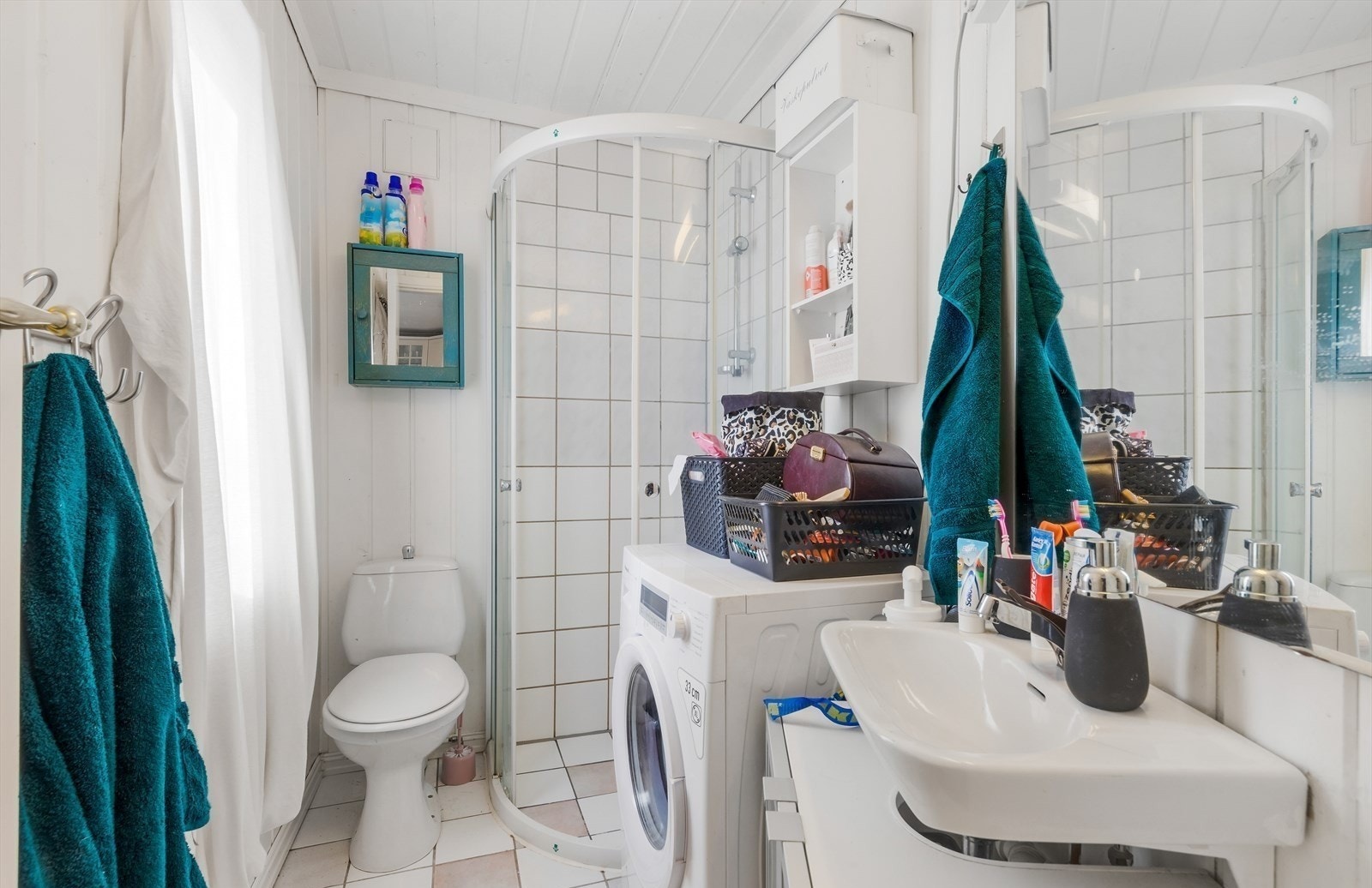 Bad med toalett, dusjhjørne og servant m/innredning. Opplegg for vaskemaskin. Galleribilde