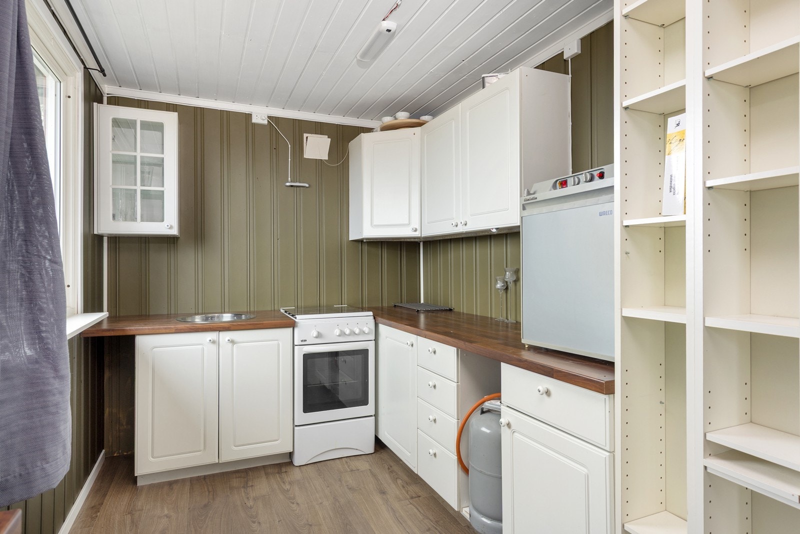 Kjøkkenet har innredning med profilerte fronter og en benkeplate av laminat. Galleribilde