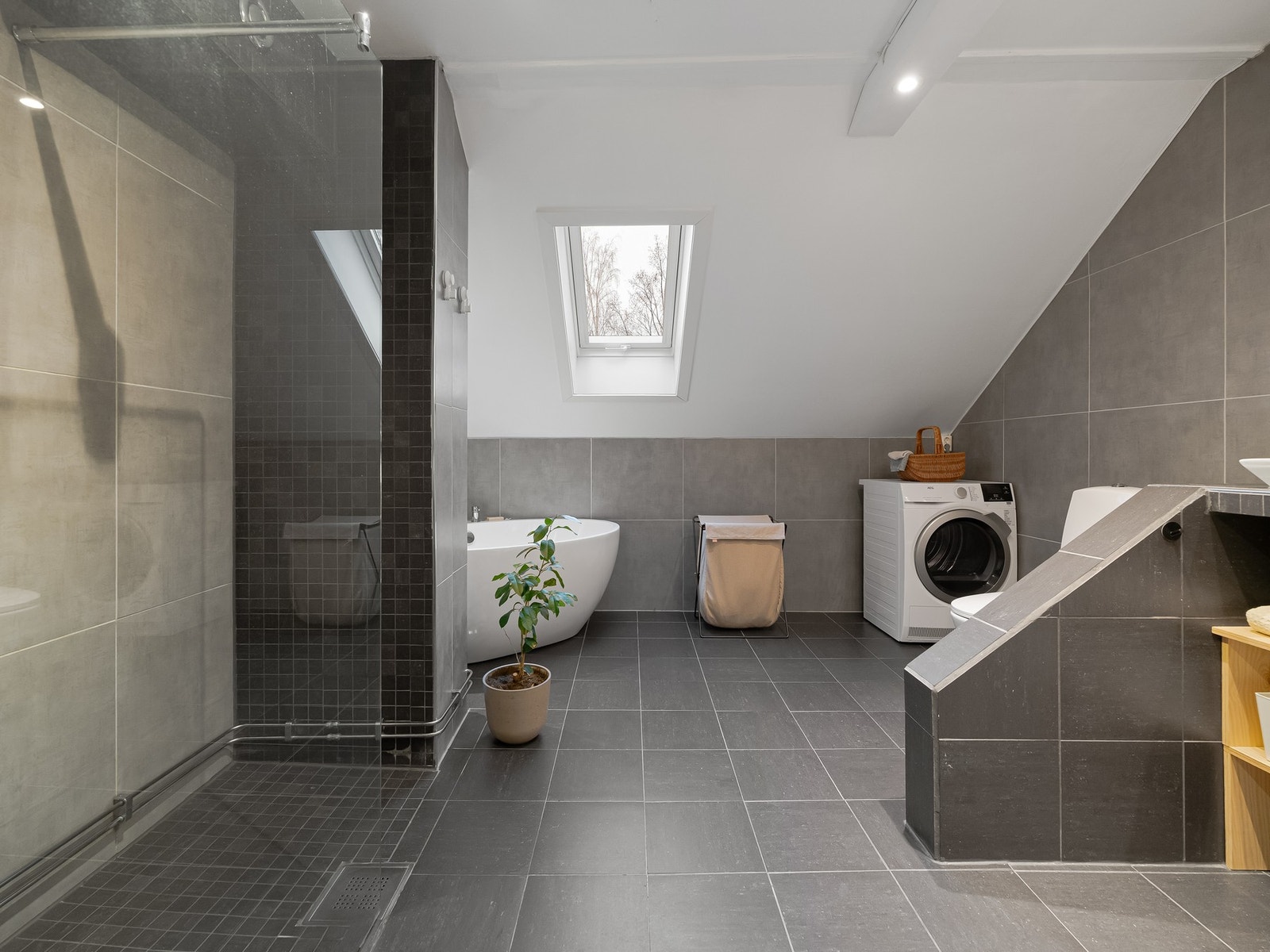 Leiligheten har et stort og romslig bad som er pent flislagt. Galleribilde