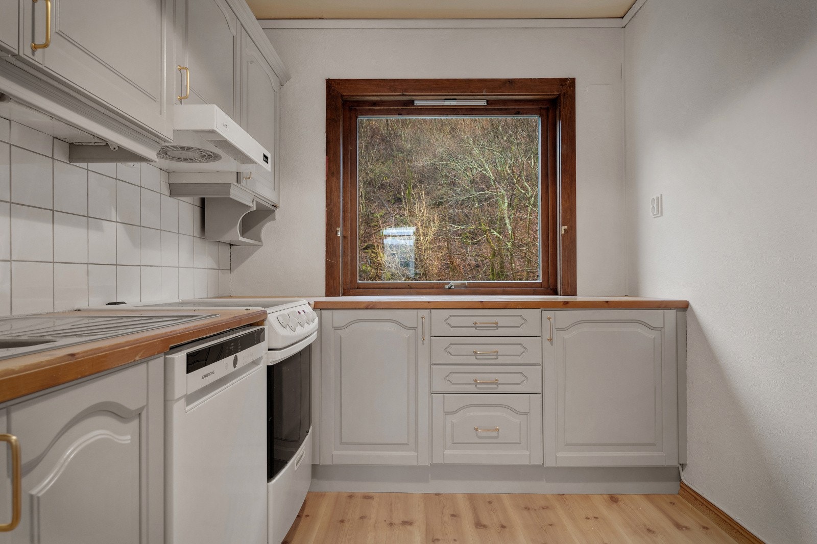 Kjøkkenet har en tidløs innredning med profilerte fronter og benkeplate i tre. Galleribilde