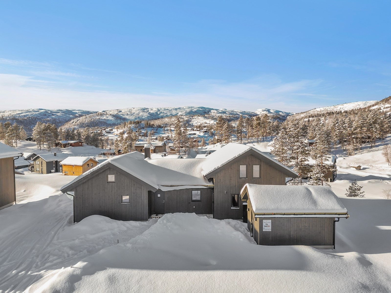 Vinterbilde - Det er oppkjørt skiløype rett utenfor hytteveggen Galleribilde