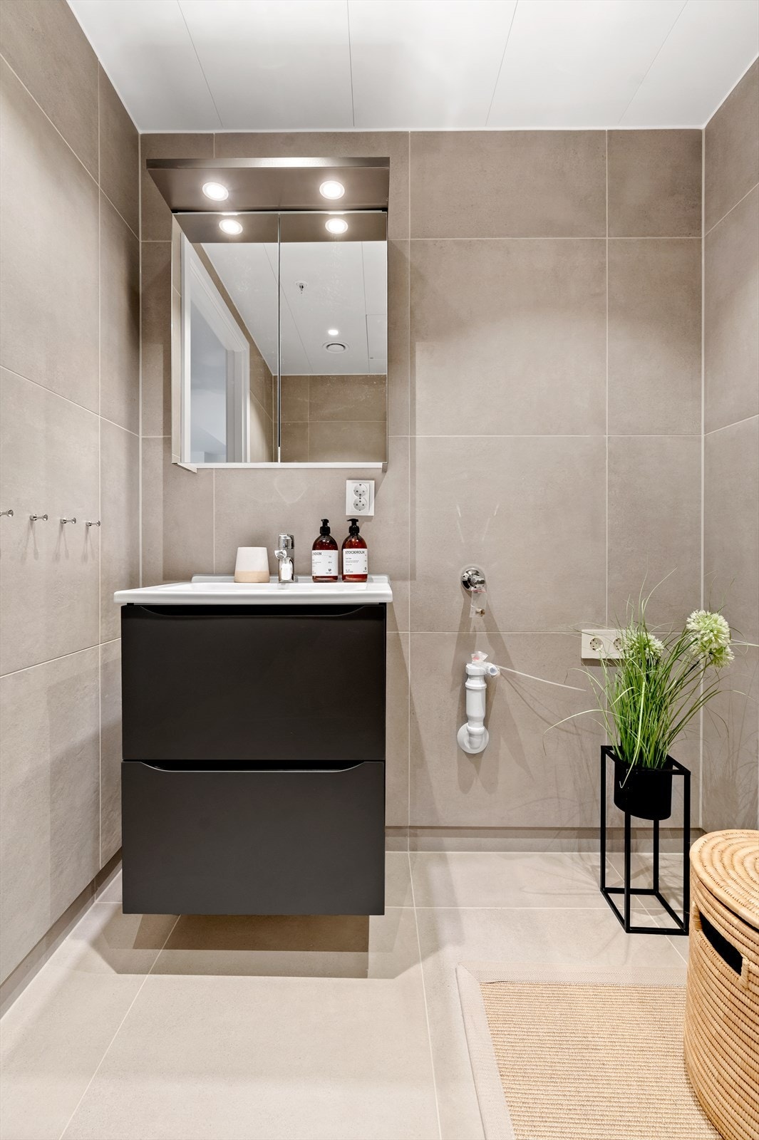 Videre er badet utstyrt med servant med skuffeinnredning, speilskap med belysning over samt opplegg for vaskemaskin. Galleribilde