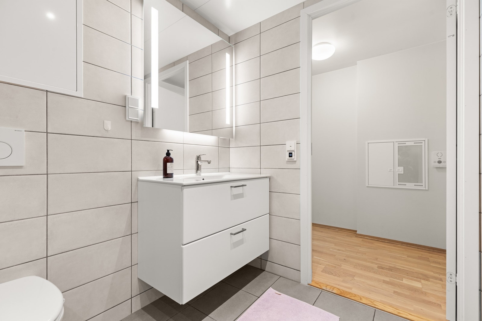 Innredningen består av vegghengt toalett, servant med innredning og dusjhjørne med glassdører. Opplegg for vaskemaskin og mekanisk avtrekk. Galleribilde