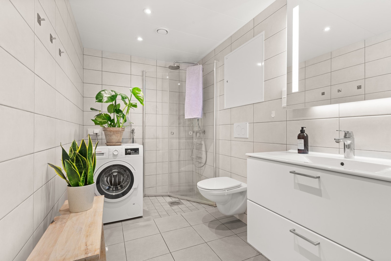 Delikat, flislagt baderom med downlights i himlingen og varme i gulvet for en lun og behagelig start på dagen. Galleribilde