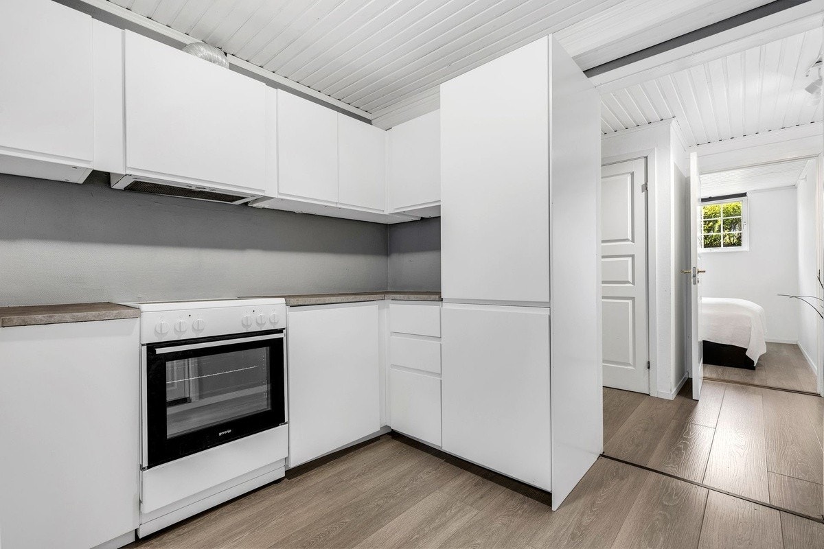 Kjøkkeninnredning med plane fronter og laminerte benkeplater Galleribilde