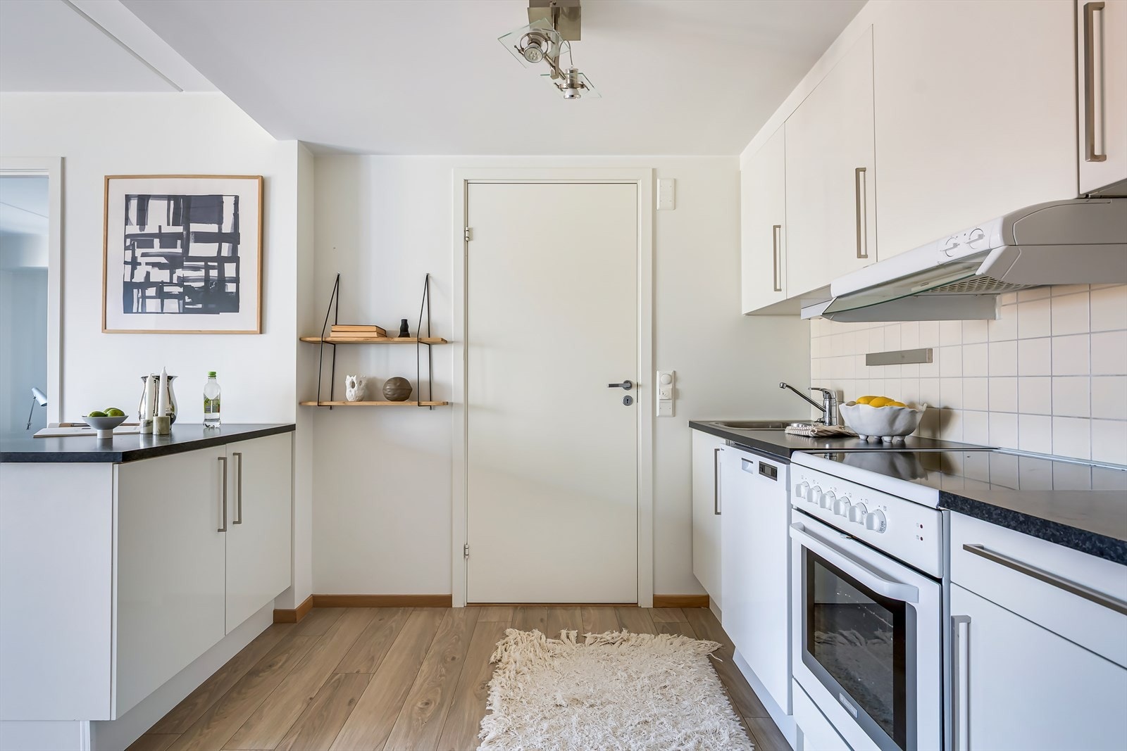 Tidløs innredning med hvite fronter, fliser på bakvegg og laminert benkeplate Galleribilde