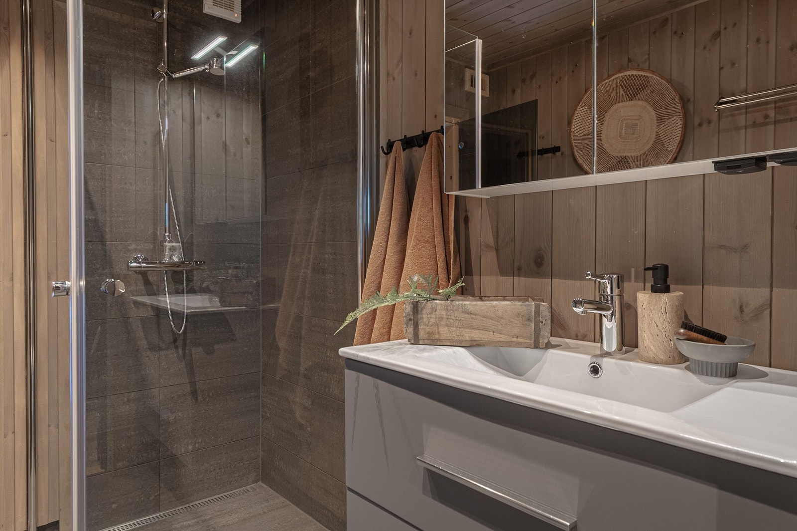 Badet er stilrent innredet med servant med underskap og dusjvegger. Galleribilde