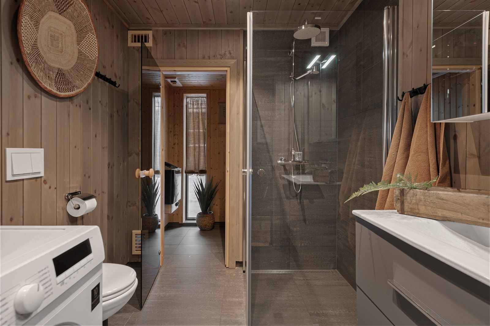 Hytta har to delikate, flislagte bad. Dette har adkomst til badstue og opplegg for vaskemaskin. Galleribilde