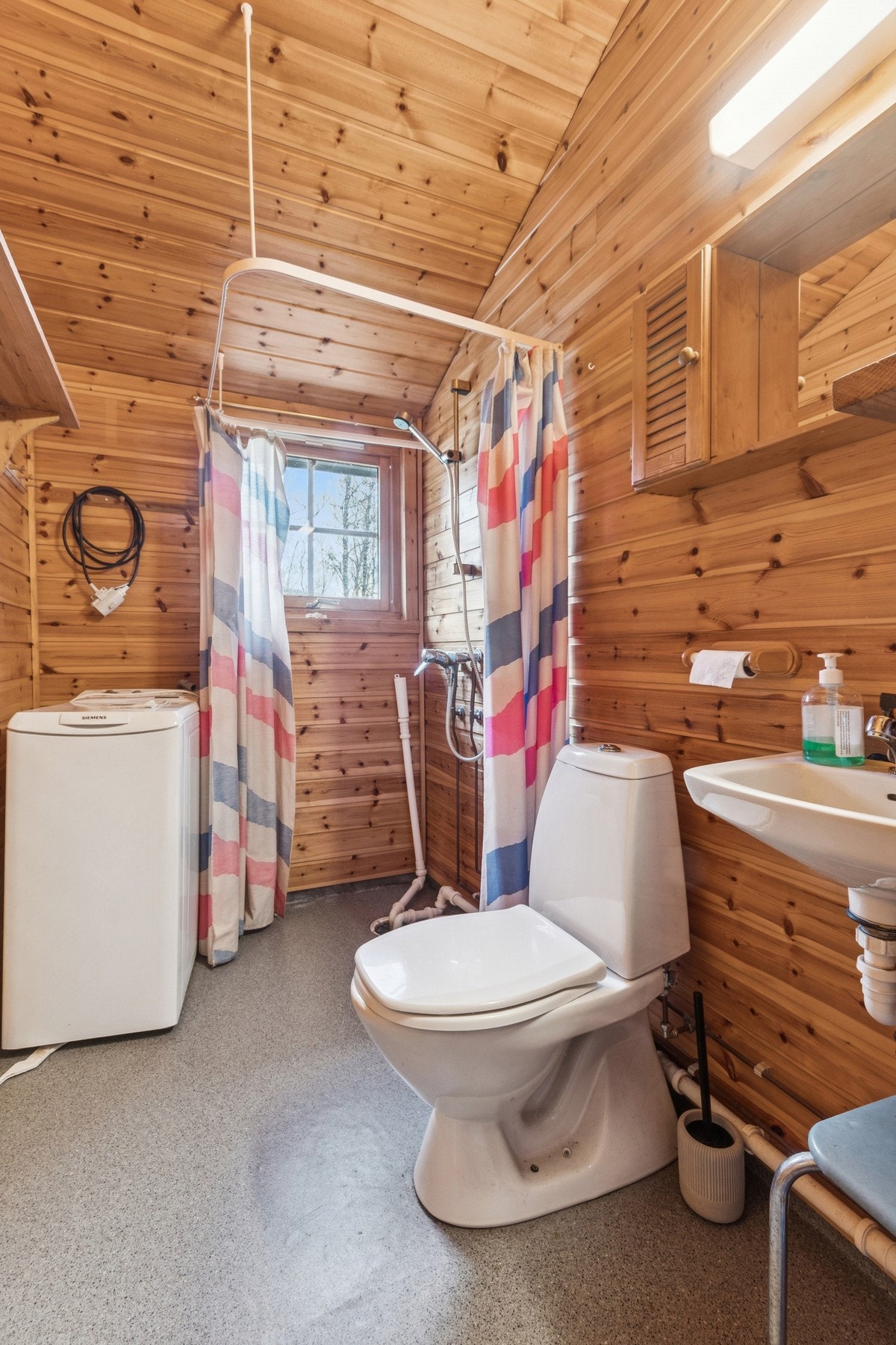 Badet er innredet med vask, speilskap, toalett, dusj og opplegg for vaskemaskin. Galleribilde